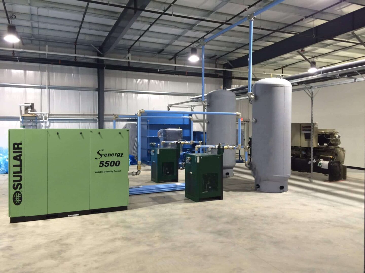 Large industrial compressor room with Sullair Air Compressor air dryer and air tank with piping